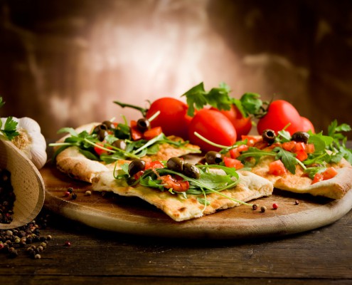 Pizza aus dem Steinofen mit Tomaten und Rucola